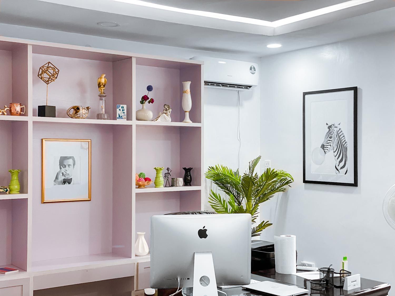 A room that incorporates green elements, a plant and a framed zebra picture