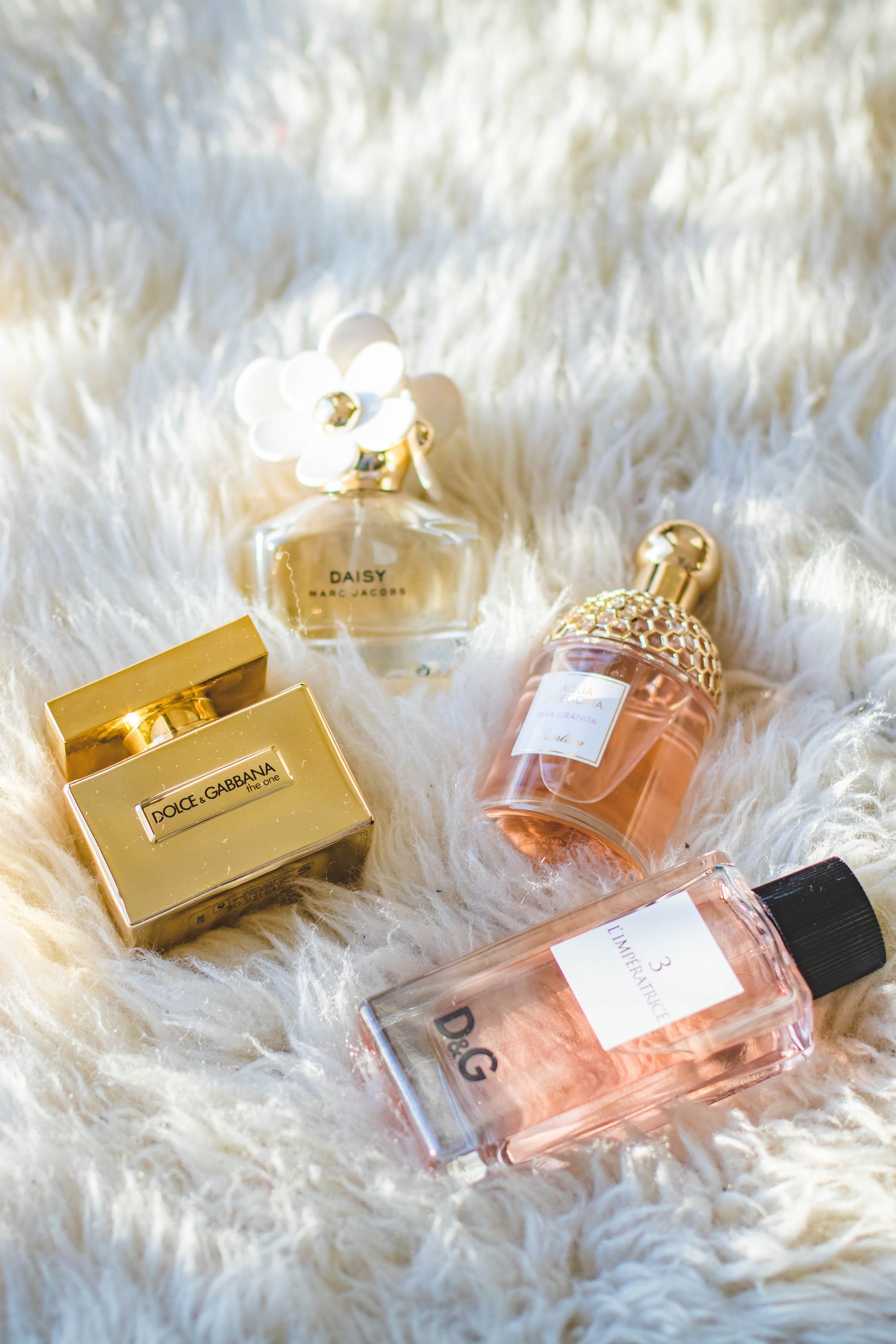 Three perfumes on a lush rug